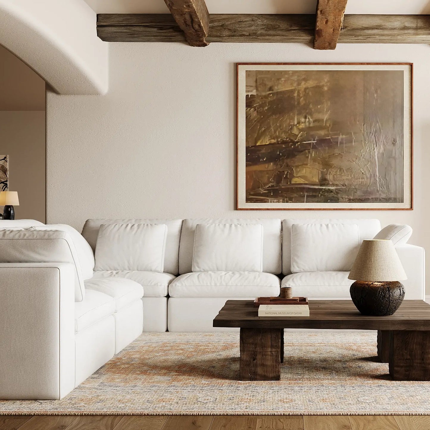 The quiet living room is furnished with a modular five-seater L-shaped white sofa.