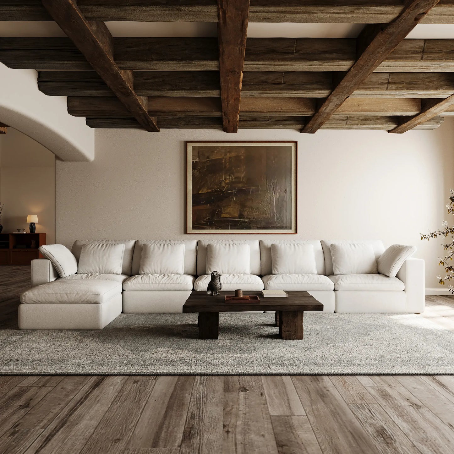 A modular white L-shaped sofa that seats six is placed in the open living room in a quiet style.