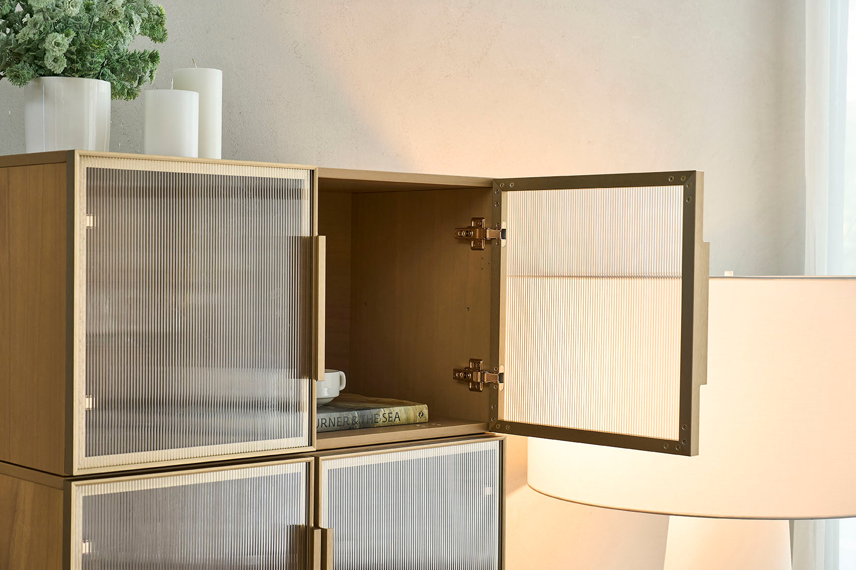 Details of the cozy nest's Italian minimalist style 4-drawer chest in natural wood tones with translucent double doors.